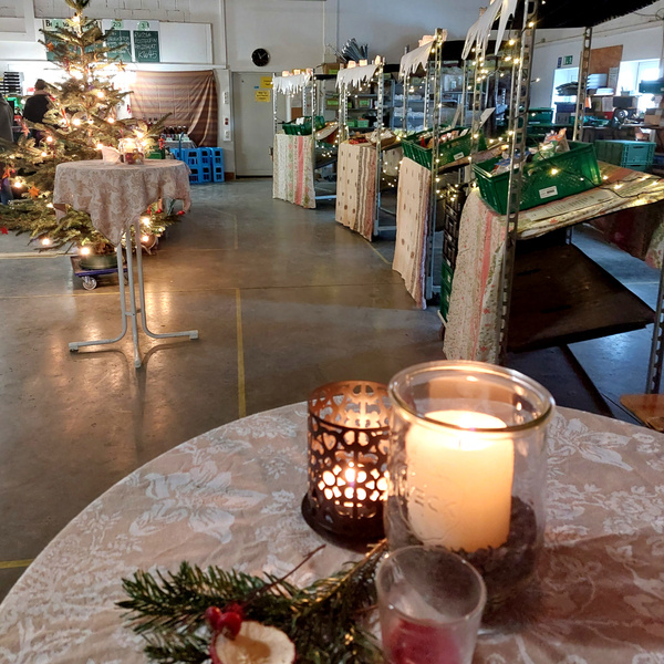 KI generiert: Weihnachtlich dekorierter Raum mit Tannenbaum, Kerzen und beleuchteten Regalen.