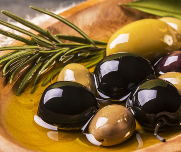 KI generiert: Oliven und Rosmarinzweige in einer Schale mit Öl.