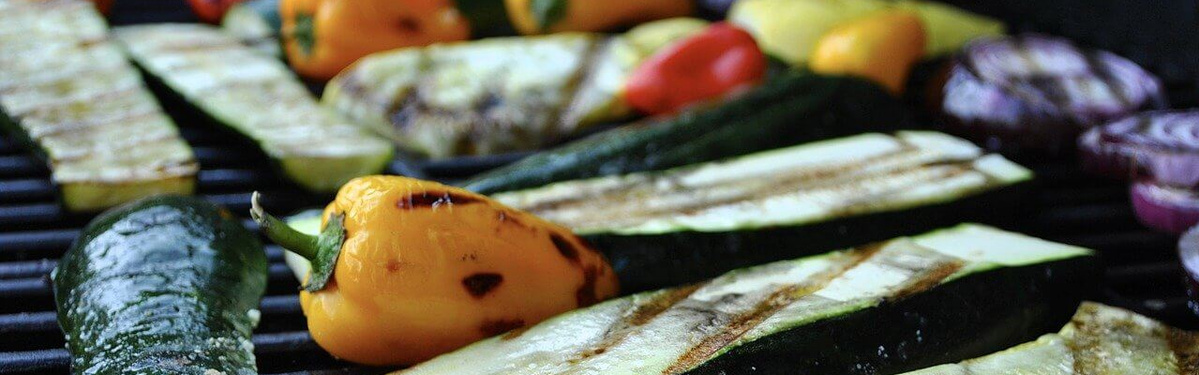 KI generiert: Gegrilltes Gemüse, darunter Zucchini und Paprika, auf einem Grill.
