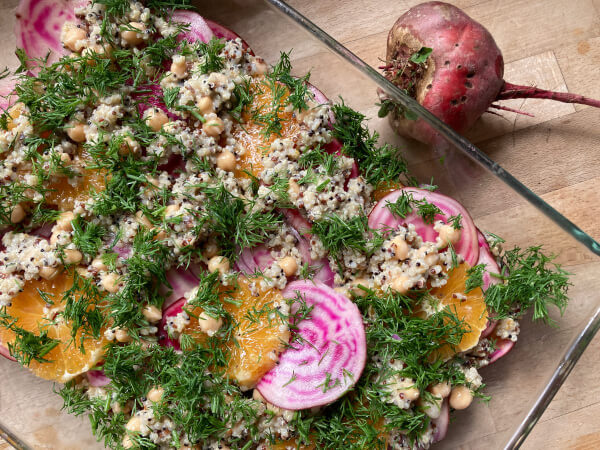 KI generiert: Ein bunter Salat mit Rote Bete, Orangen, Kräutern und Kichererbsen in einer Glasschüssel.