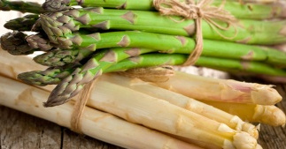 KI generiert: Ein Bündel grüner und ein Bündel weißer Spargel auf Holz.