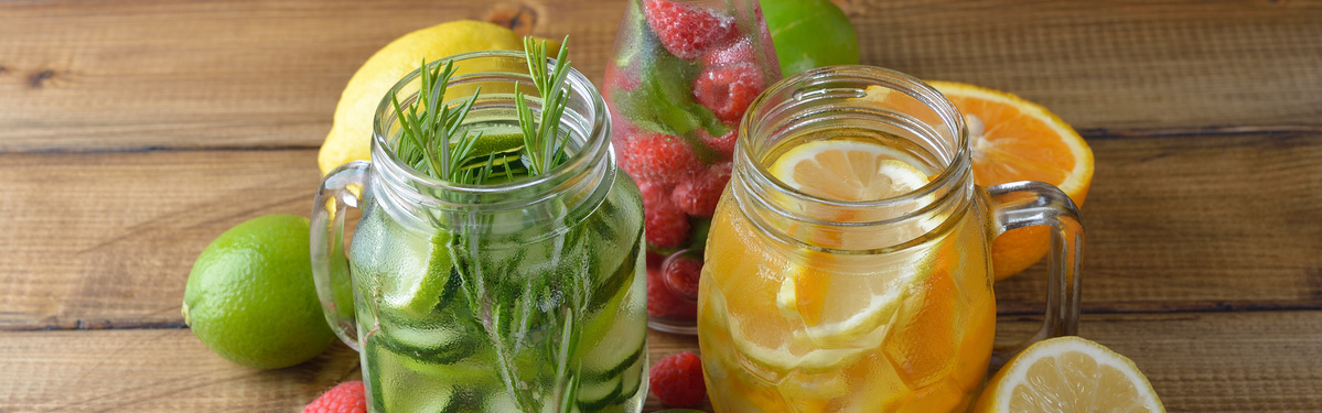 KI generiert: Zwei Gläser mit fruchtigem Wasser: eines mit Gurken und Kräutern, das andere mit Zitrusfrüchten.