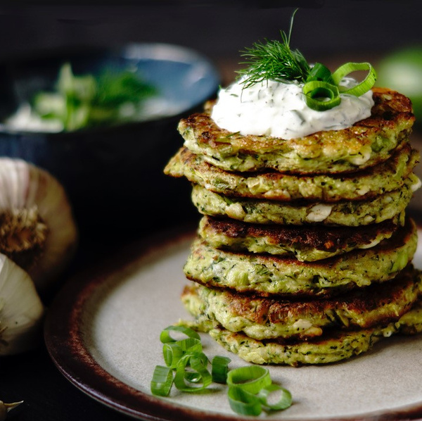 KI generiert: Das Bild zeigt eine Tasse mit frisch gebrühtem Tee und einem Teesieb. Daneben liegt ein Jutebeutel mit der Aufschrift "Tea" und lose Teeblätter.