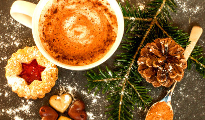 KI generiert: Eine Tasse Kaffee, Weihnachtsplätzchen, Tannenzweig und einen Tannenzapfen auf einem Tisch.