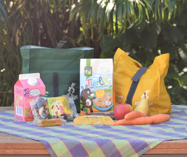 KI generiert: Verschiedene Bio-Snacks in Taschen, Milch und Kekse mit dem Text "Tierlix".