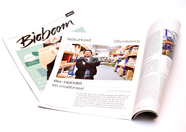 KI generiert: Zwei geöffnete Bio-Magazine mit Bericht über "Bio-Handel im Großformat".