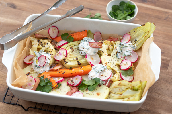 KI generiert: Gemüse-Auflauf mit Möhren, Fenchel, Radieschen und Kräutercreme in einer weißen Auflaufform.