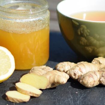 KI generiert: Honig, Ingwer, Zitrone und Tee auf einem Tisch.
