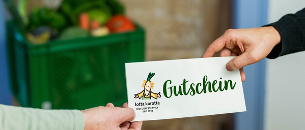 KI generiert: Zwei Hände tauschen einen Gutschein, im Hintergrund eine Kiste mit Gemüse. Text: "Gutschein lotta karotta".