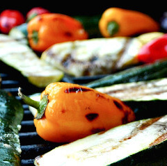 KI generiert: Gegrilltes Gemüse auf einem Grillrost, darunter bunte Paprika und Zucchinischeiben.