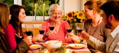 KI generiert: Eine Gruppe von Menschen stößt bei einem Abendessen mit Rotwein an.