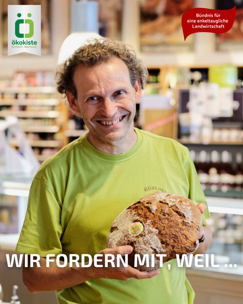 KI generiert: Ein Mann hält ein Brot in einem Laden. Text: "WIR FORDERN MIT, WEIL ..."