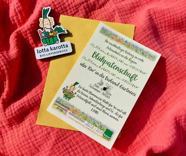 KI generiert: Eine Blühpatenschaft-Urkunde von "lotta karotta" auf einem roten Stoff.