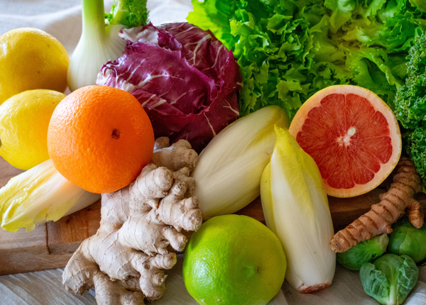KI generiert: Frisches Obst und Gemüse auf einem Holzbrett, darunter Zitrusfrüchte, Salate und Ingwer.