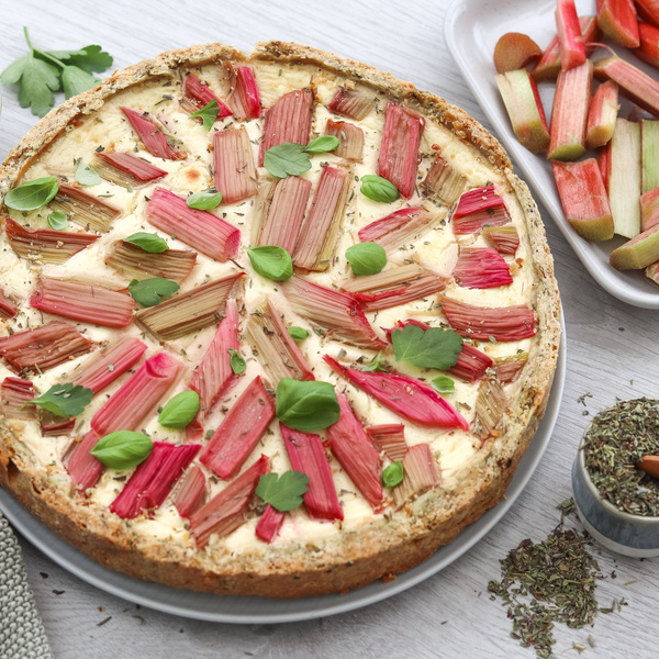 KI generiert: Ein Rhabarberkuchen mit frischen Kräutern und Rhabarberstreifen als Hauptinhalt.