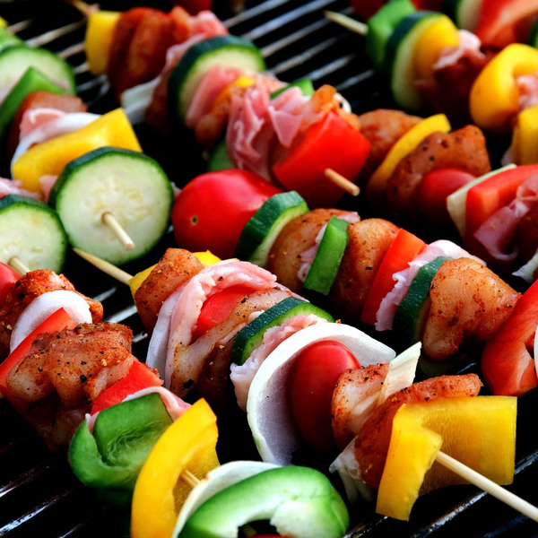 KI generiert: Bunte Gemüsespieße auf einem Grill mit Hähnchen, Paprika, Zucchini und Tomaten.